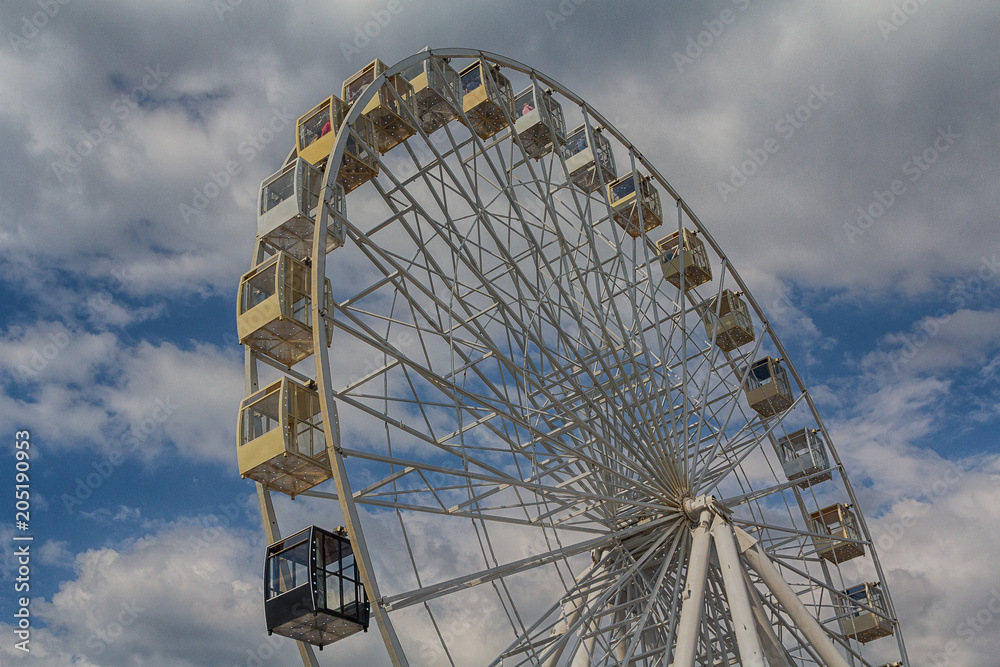 Fototapeta premium Ferris wheel on background cloudy sky. Festival