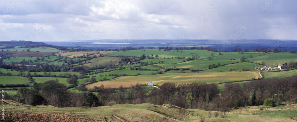 Spring sunshine and showers on the rolling Cotswold countryside between Edge and Painswick Beacon, Gloucestershire, UK