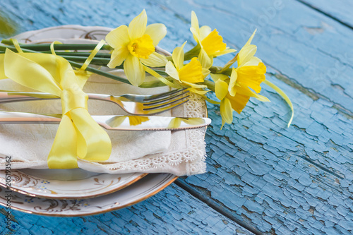 Fototapeta Naklejka Na Ścianę i Meble -  Set of tableware and a bouquet of yellow narcissus