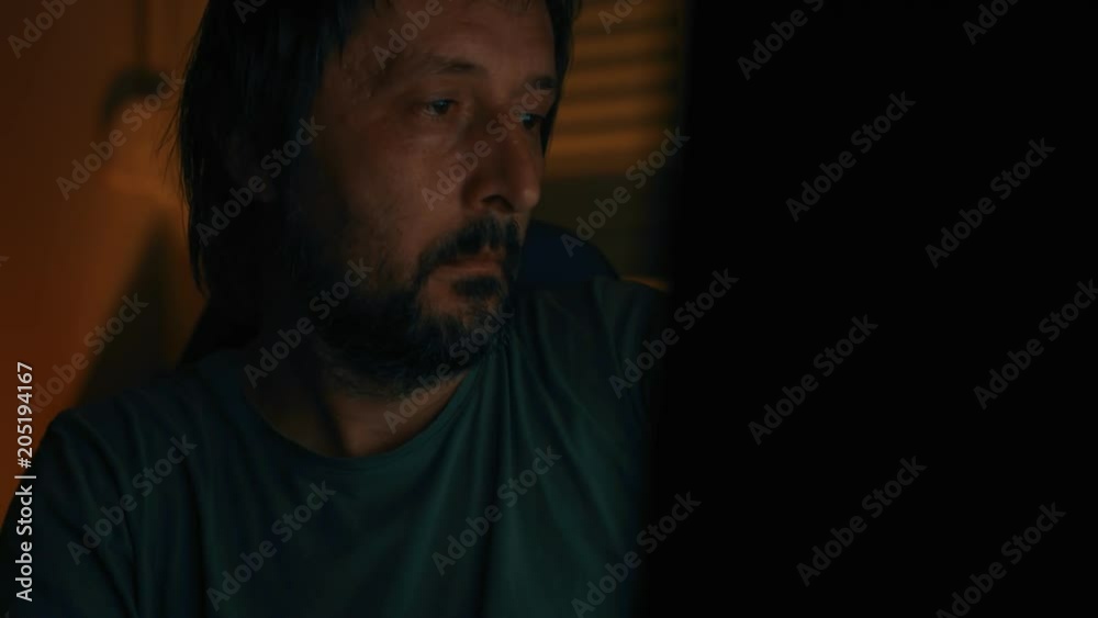 Man surfing internet at night at home computer in dark room, low key footage Man surfing internet at night at home computer in dark room, low key footage
