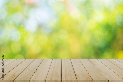 Top of wood table empty ready for your product and food display or montage background with bokeh green abstract background.