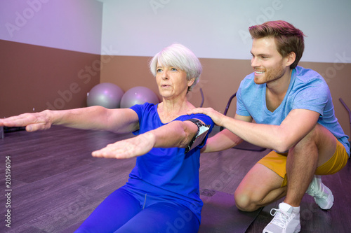senior woman training pilates with instructor