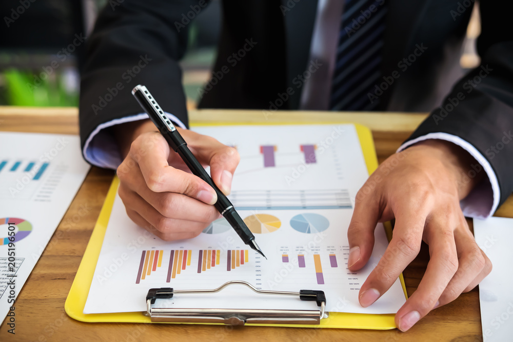 Asian business people meeting working with new startup project pointing graph discussion and analysis data charts and graphs.Business finances and accounting concept