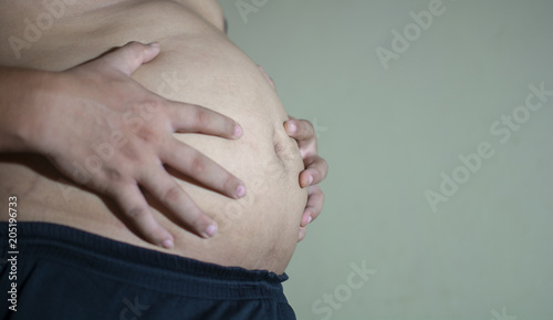 fat man touching his big belly