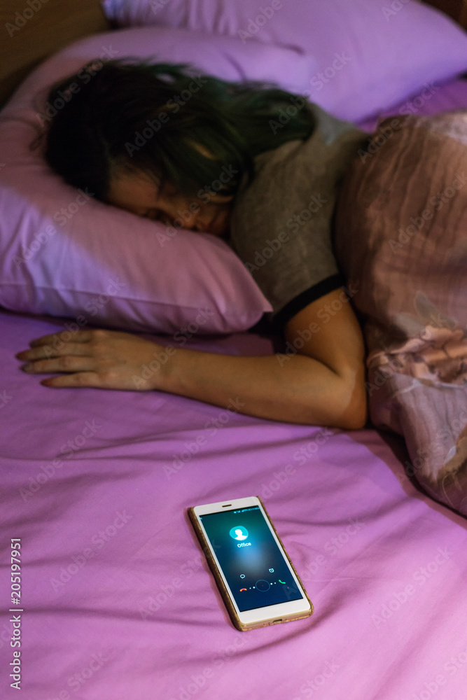 Sleeping Asian woman with office call on phone screen Sleeping Asian woman with office call on phone screen