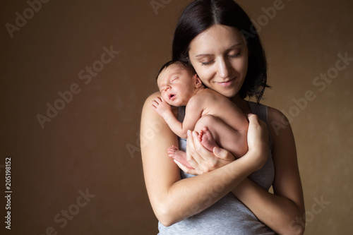 Young mother holding her newborn sleeping baby