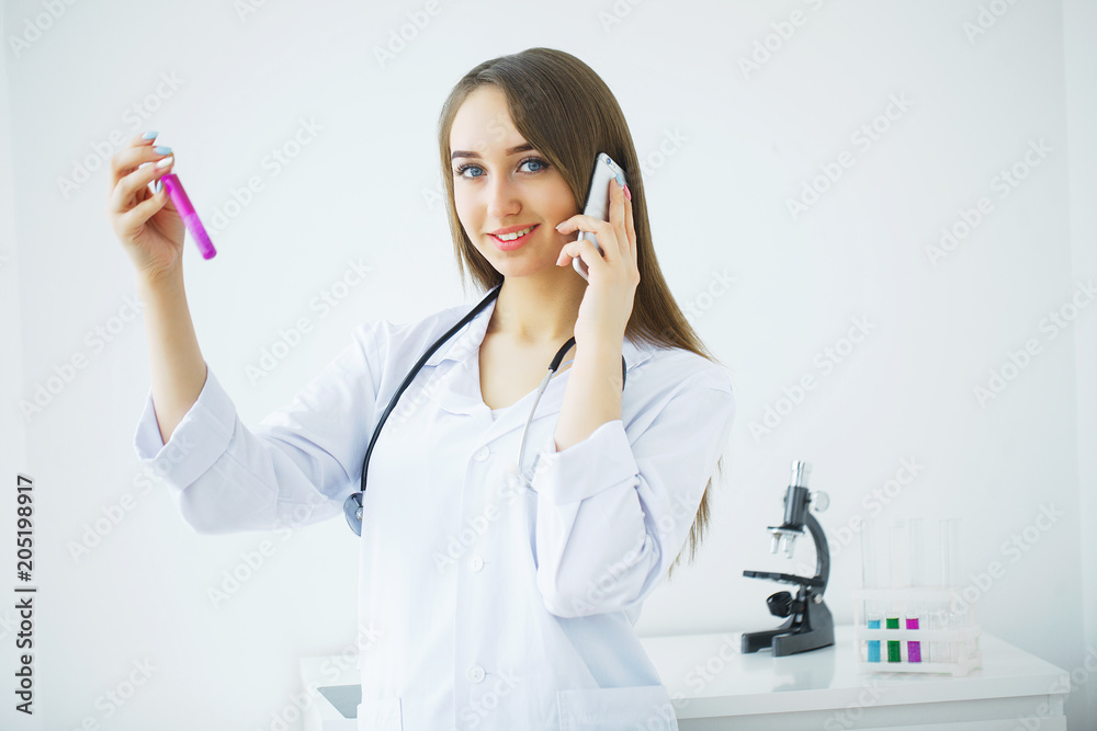 Female medical or research scientist or doctor using looking at a test tube of clear solution in a lab or laboratory. Female medical or research scientist or doctor using looking at a test tube of clear solution in a lab or laboratory.