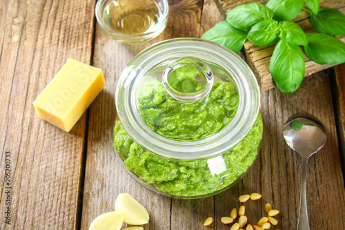 Homemade pesto sauce. Ingredients. Cheese, garlic, basil, pine nuts, olive oil on an old wooden table.