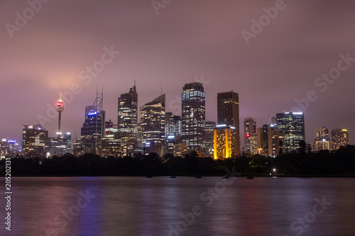 Sydney at dusk with skyscapers illuminated in Australia.