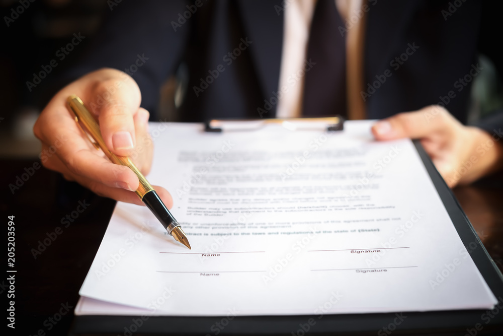 Close up business man reaching out sheet with contract agreement proposing to sign.Full and accurate details, individual who owns the business sign personally,director of the company, solicitor. Close up business man reaching out sheet with contract agreement proposing to sign.Full and accurate details, individual who owns the business sign personally,director of the company, solicitor.