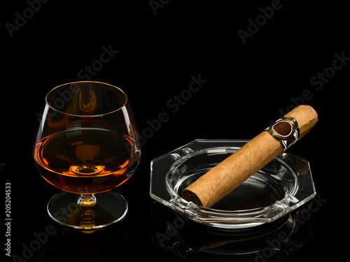Cognac and cigar in a glass ashtray
