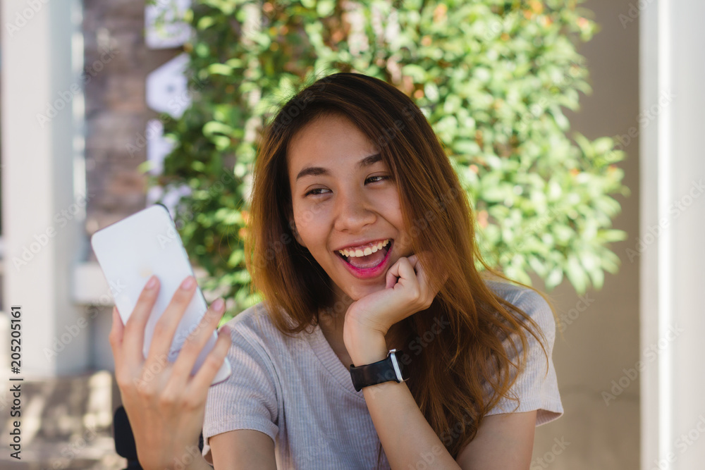 Attractive beautiful happy young Asian woman taking a selfie using a smart phone at cafe. Young Asian girl at restaurant taking self portrait. Attractive beautiful happy young Asian woman taking a selfie using a smart phone at cafe. Young Asian girl at restaurant taking self portrait.