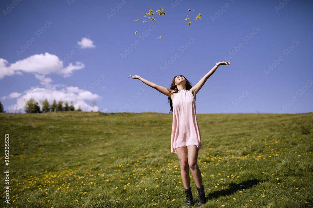 A beautiful woman in her dress enjoys a glade of mountain flowers A beautiful woman in her dress enjoys a glade of mountain flowers