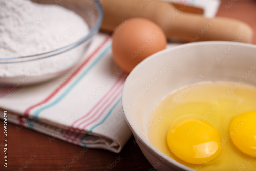 pizza or pie recipe ingridients, food flat lay on wood kitchen table background. baking ingredients. Bowl, eggs, milk, flour, eggbeater, rolling pin and eggshells pizza or pie recipe ingridients, food flat lay on wood kitchen table background. baking ingredients. Bowl, eggs, milk, flour, eggbeater, rolling pin and eggshells