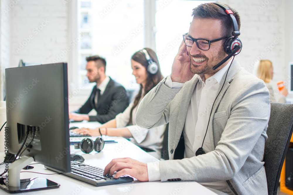 Smiling call center worker with headset giving technical support to customers. Smiling call center worker with headset giving technical support to customers.