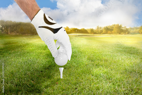 Golfer legt Golfball auf das tee für den Abschlag