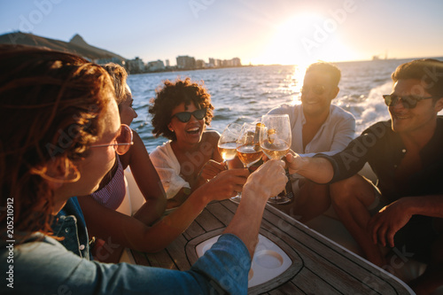 Cheerful friends drinking together on yacht
