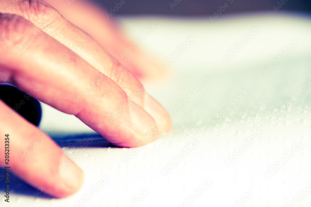 Hands reading braille writing on book Hands reading braille writing on book