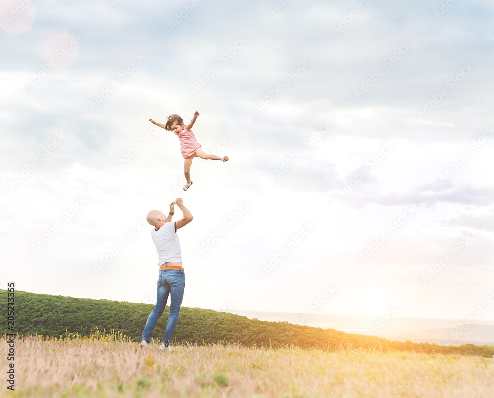 Father playing with his daughter in sunny field Father playing with his daughter in sunny field
