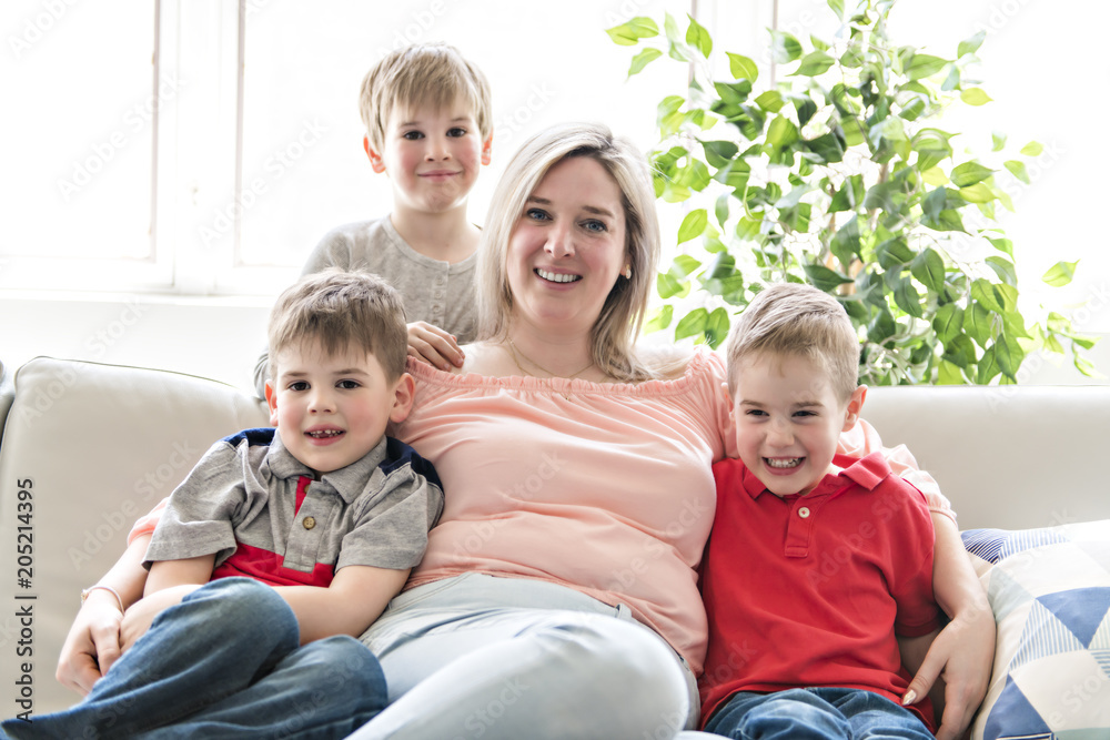 Happy young woman with children on sofa at home Happy young woman with children on sofa at home