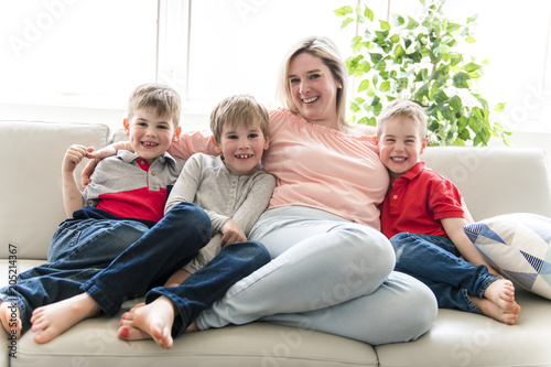 Happy young woman with children on sofa at home