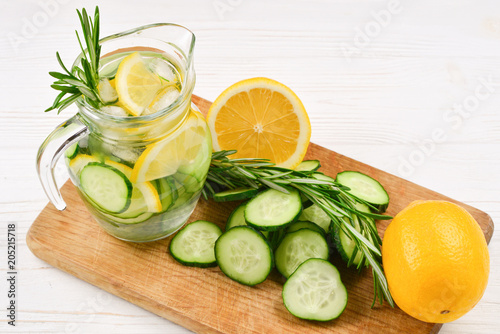 Cold and refreshing detox water with lemon, cucumber, rosemary and ice in glass jar. Copyspace. Banner