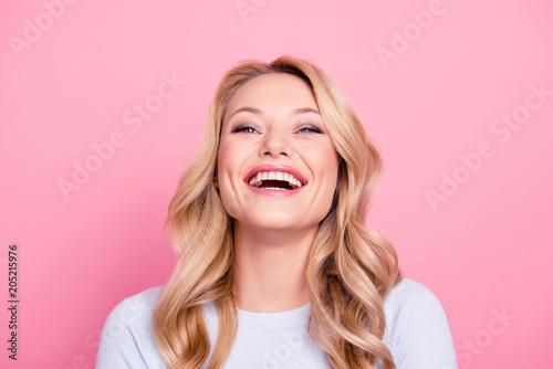 Portrait of foolish positive girl with modern hairstyle laughing sincerely with beaming smile isolated on pink background. Mood inspiration enjoyment pleasure concept photo