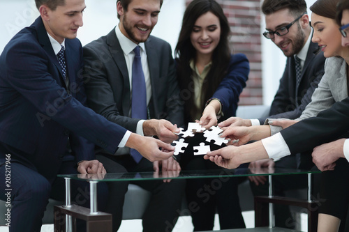 Business team solving puzzle together.