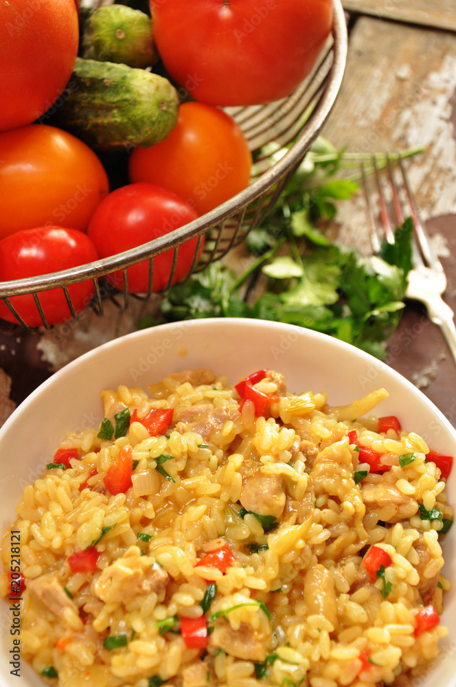 Risotto with chicken in a white bowl on a wooden background Risotto with chicken in a white bowl on a wooden background