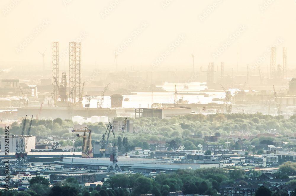 Obraz premium Aerial view across the city of Rotterdam, The Netherlands towards the harbour and industrial areas along the Nieuwe Maas river