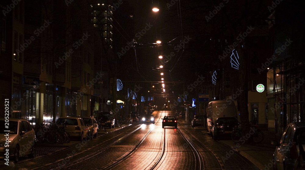 Two cars passing in an empty street at night in the city