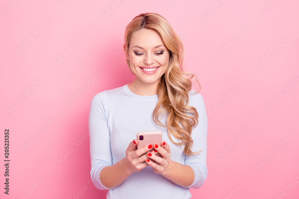 Portrait of pretty charming girl with modern hairdo having cellphone, smart phone in hands checking email, using 3G wifi internet, isolated on pink background Portrait of pretty charming girl with modern hairdo having cellphone, smart phone in hands checking email, using 3G wifi internet, isolated on pink background