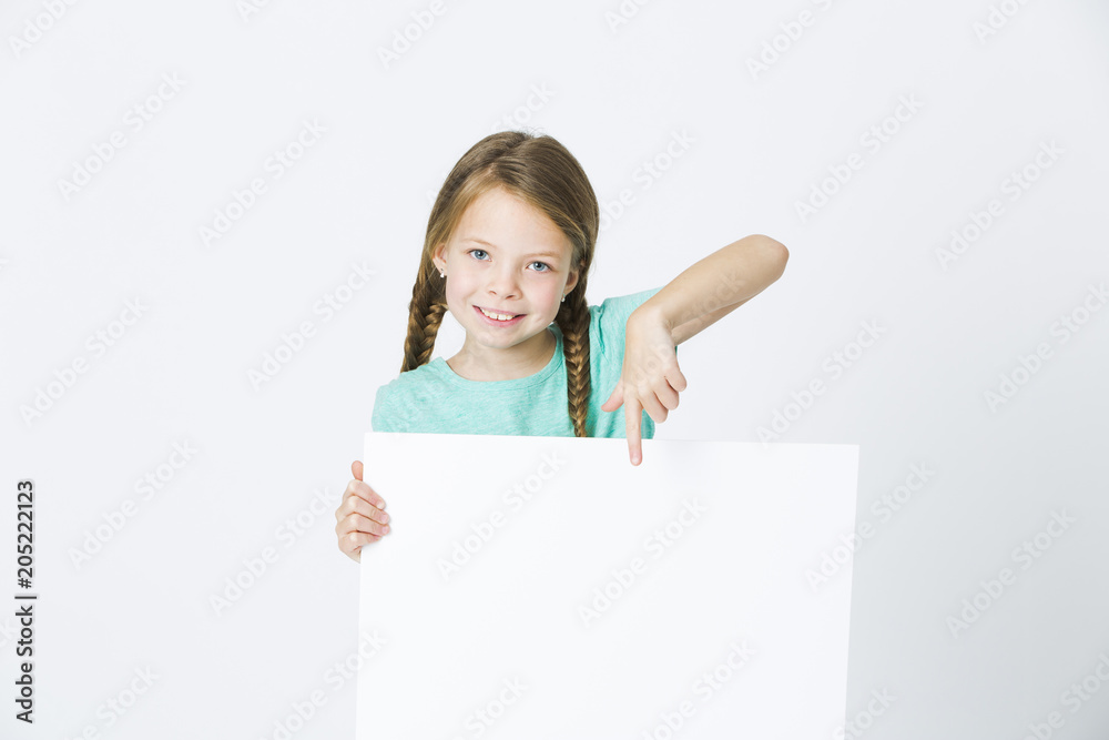 pretty, brunette girl is pointing at white board in front of white background pretty, brunette girl is pointing at white board in front of white background
