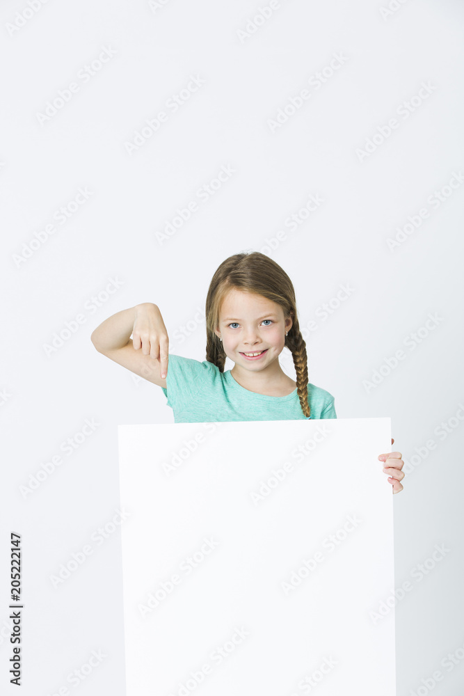 pretty, brunette girl is pointing at white board in front of white background pretty, brunette girl is pointing at white board in front of white background