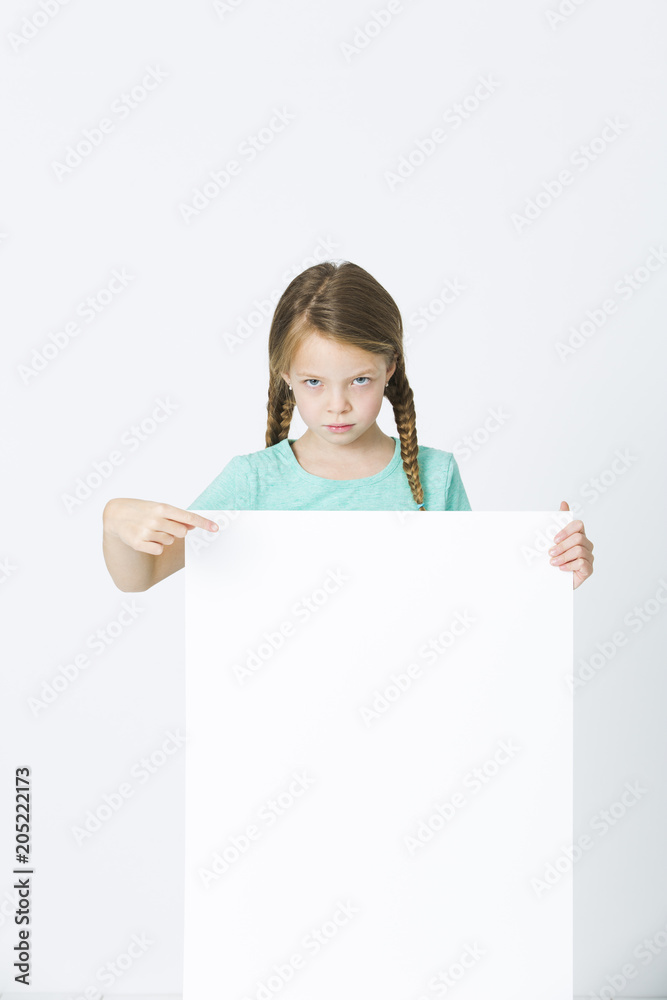 pretty, brunette girl is pointing at white board in front of white background pretty, brunette girl is pointing at white board in front of white background
