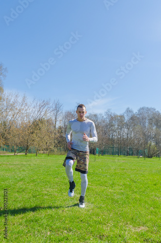 a man in sports clothes in the summer, trains in the Park