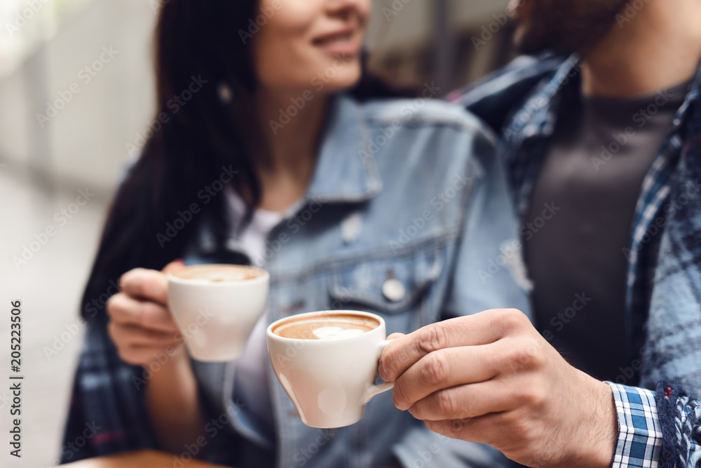 Close up. Guy with a girl is drinking coffee. Close up. Guy with a girl is drinking coffee.