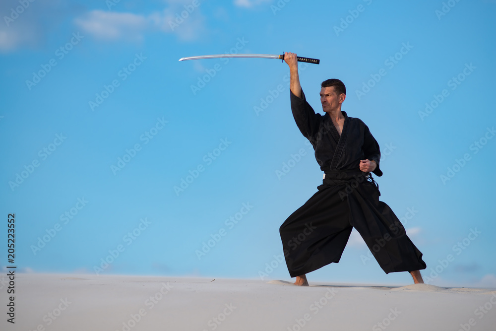 Man is training Japanese martial arts in desert Man is training Japanese martial arts in desert