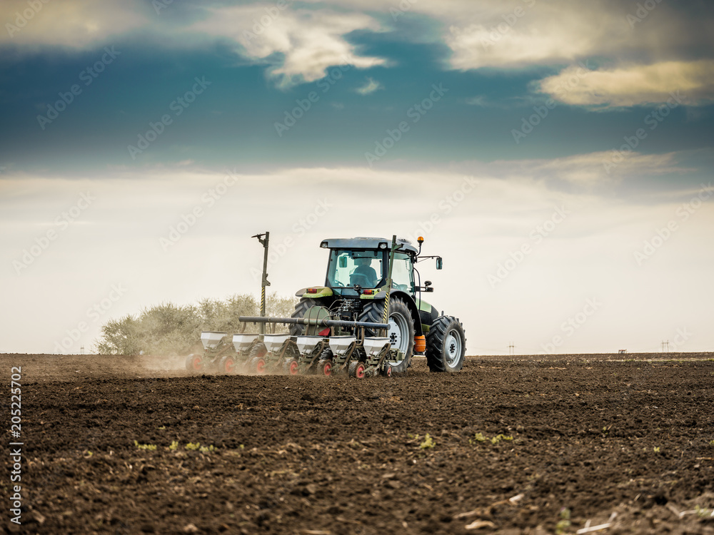 Farmer seeding, sowing crops at field. Sowing is the process of planting seeds in the ground as part of the early spring time agricultural activities. Farmer seeding, sowing crops at field. Sowing is the process of planting seeds in the ground as part of the early spring time agricultural activities.