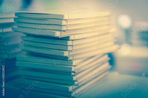 Many books stacked on a table in a library.