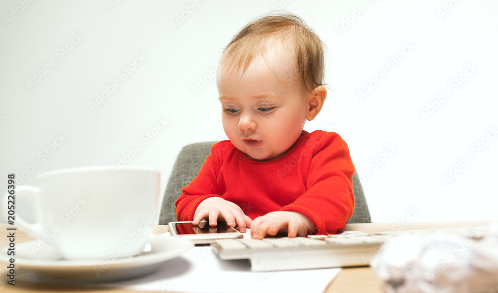 Happy child baby girl toddler sitting with keyboard of computer isolated on a white background Happy child baby girl toddler sitting with keyboard of computer isolated on a white background