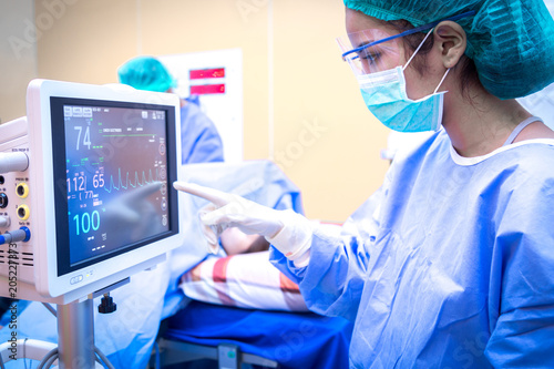 Female surgeon using monitor in operating room. photo