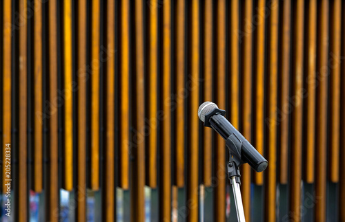 microphone on stand on brown wood background, microphone ready for opening ceremony