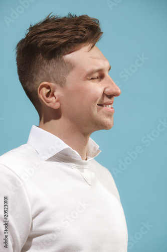 The happy business man standing and smiling against studio background.