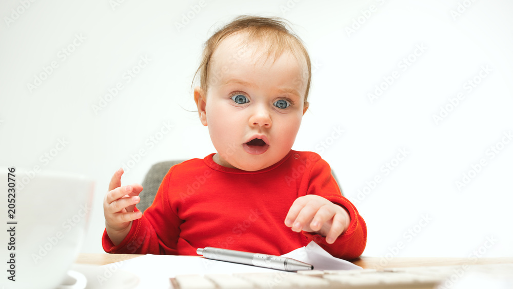 Happy child baby girl toddler sitting with keyboard of computer isolated on a white background