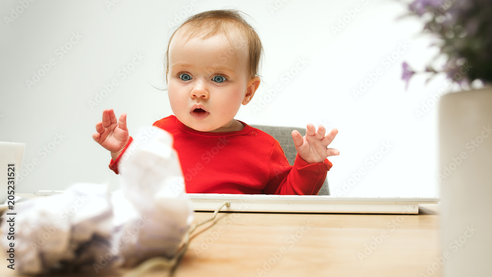 Happy child baby girl toddler sitting with keyboard of computer isolated on a white background Happy child baby girl toddler sitting with keyboard of computer isolated on a white background