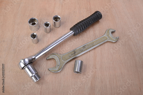 various professional metalwork tools on a background of beech wood