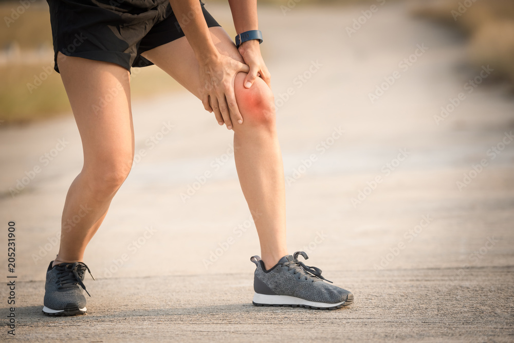 woman runner hold her sports injured knee