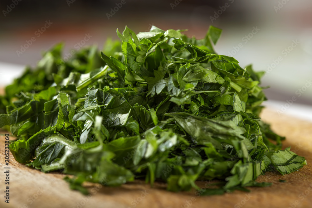 Close up of fresh green chopped parsley on wood Close up of fresh green chopped parsley on wood