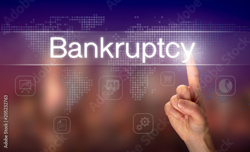 A hand selecting a Bankruptcy business concept on a clear screen with a colorful blurred background.